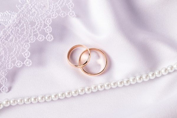 Two,Gold,Wedding,Rings,On,A,White,Satin,Background,With